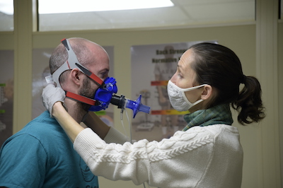 Kerry Watson adjusts a metabolic testing mask on Michael Crossett, both Army Wellness Center health educators, before beginning his assessment.