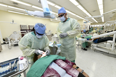 Dental students practice their skills while treating Soldiers, dependents, and retirees